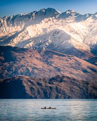 Scenic view of lake by snowcapped mountains