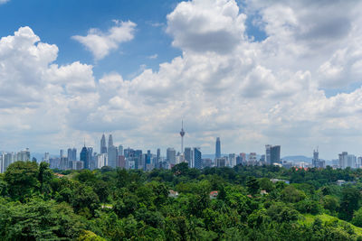 View of modern buildings against cloudy sky