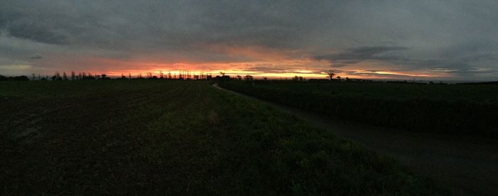 Scenic view of farm against sky during sunset