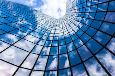 Low angle view of modern building against cloudy sky