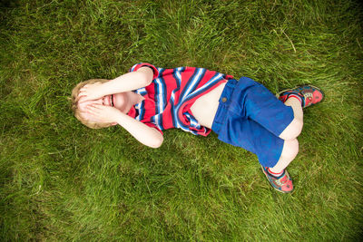 High angle view of boy lying on grass