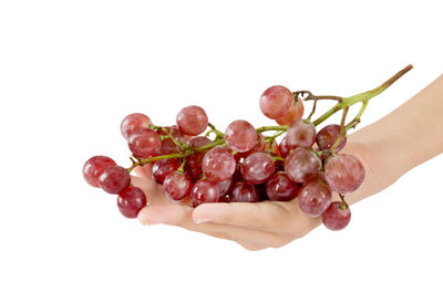 Close-up of hand holding strawberry over white background