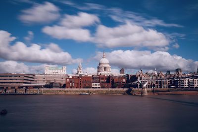 Buildings in city against cloudy sky