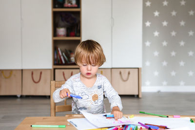 Little boy drawing with felt-tip pens