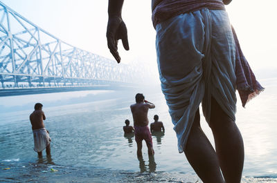 People at beach against sky