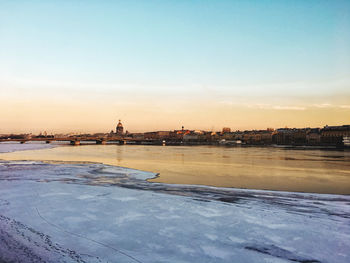 Scenic view of frozen river during sunset