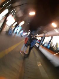 Blurred motion of people on illuminated escalator in city