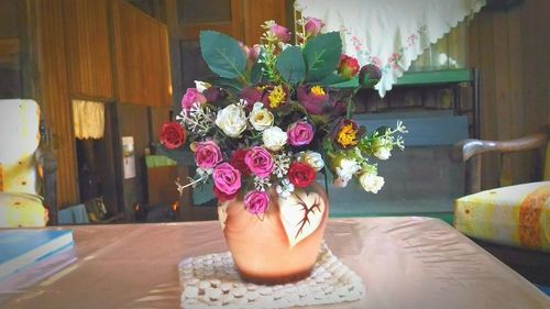 Low section of woman with flower vase on table