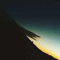 Low angle view of silhouette mountain against sky at night