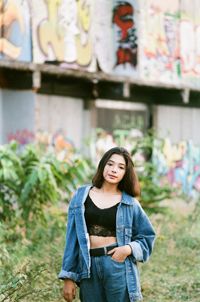 Portrait of smiling woman standing against wall