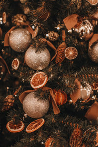 Creative christmas tree decorated with dry oranges, pine cones, golden balls. magic cozy details,