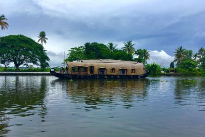 Built structure by river against sky