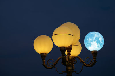 Low angle view of illuminated street light against sky