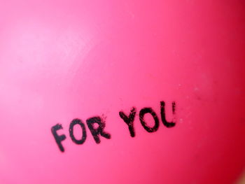 Close-up of text on pink wall
