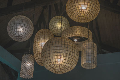 Low angle view of illuminated pendant lights hanging from ceiling