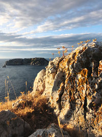 Rock formation on beach against sky