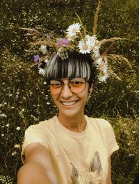 Portrait of a smiling young woman against white flowering plants