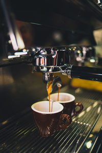 Close-up of coffee cup on espresso maker in cafe