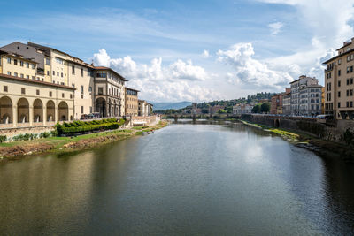 Arch bridge over river against buildings in city