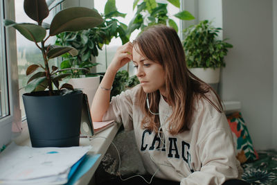 A young pretty woman in headphones communicates via video chat with mobile phone. high quality photo