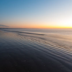 Scenic view of sea against clear sky during sunset