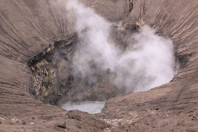 High angle view of smoke emitting from volcanic mountain