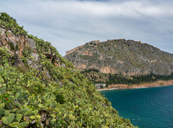 Scenic view of sea and mountains against sky