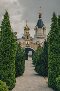 Temple amidst trees and building against sky