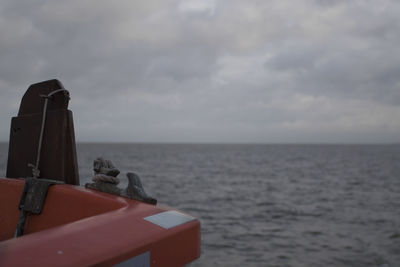 Close-up of boat in sea against sky