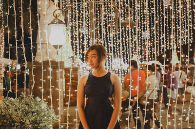 Portrait of young woman standing at night