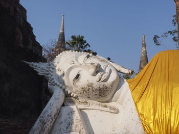 Low angle view of statue against building against clear sky