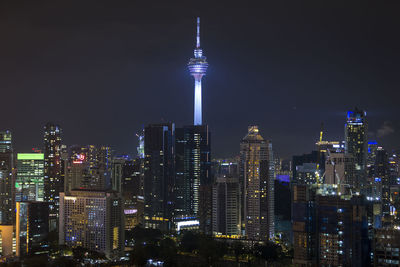 Illuminated modern buildings against sky at night