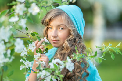 Portrait of woman holding flowering plant