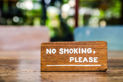Close-up of no smoking sign on wooden table