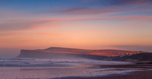 Scenic view of beach against sky during sunset