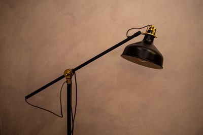 Close-up of light bulb hanging against wall