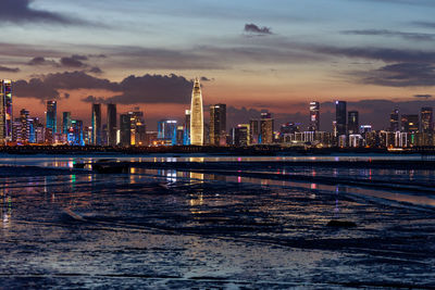 Illuminated buildings against sky during sunset