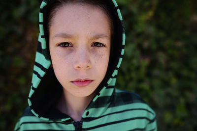 Portrait of confident boy in hood at park