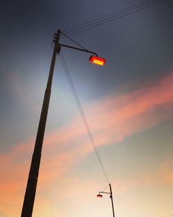 Low angle view of illuminated crane against sky during sunset