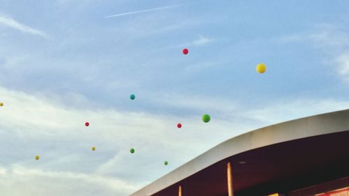 Low angle view of colorful balloons against sky