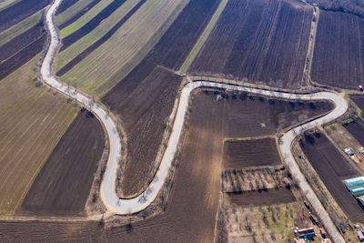 Aerial view of winding countryside road and agricultural fields from a drone