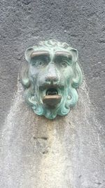 Close-up of old statue against wall