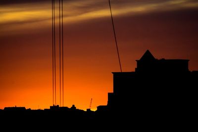 Silhouette of building against orange sky