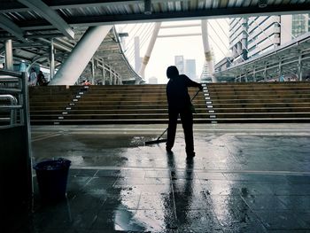 Rear view of man standing on wet floor in building