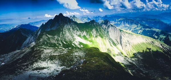 Panoramic view of sea and mountains against blue sky