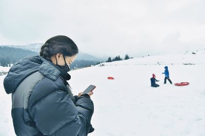 People on snow covered mountain against sky