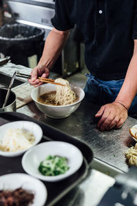 Midsection of chef preparing food in kitchen