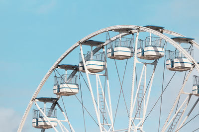 Low angle view of ferris wheel against clear blue sky