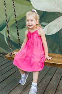 Portrait of cute girl sitting on wooden floor