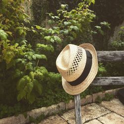 Close-up of straw hat on wooden fence